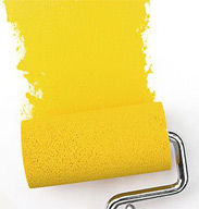 Paint roller with yellow paint spread.